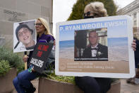 Jen Trejo, left, from California holds a sign that reads "JAIL TIME FOR THE SACKLERS" in one hand and a photo of her son Christopher in the other who died from opioid addiction at 32, and Kathy Moorehead of Louisville, Ky., holds a sign of P. Ryan Wroblweski, during a protest with other advocates for opioid victims outside the Department of Justice, Friday, Dec. 3, 2021, in Washington. A federal judge has rejected OxyContin maker Purdue Pharma’s sweeping deal to settle thousands of lawsuits over the toll of opioids. U.S. District Court Judge Colleen McMahon in New York found flaws in the way the bankruptcy settlement protects members of the Sackler family who own the company from lawsuits. (AP Photo/Carolyn Kaster)