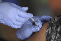 A man receives a shot of the Sinovac COVID-19 vaccine during a vaccination campaign at the Patriot Candrabhaga Stadium in Bekasi on the outskirts of Jakarta, Indonesia Friday, Nov. 26, 2021. Indonesia has significantly recovered from a mid-year spike in coronavirus cases and deaths that was one of the worst in the region, but with its vaccination drive stalling and holidays approaching, experts and officials warn the island nation could be set soon for another surge. (AP Photo/Achmad Ibrahim)