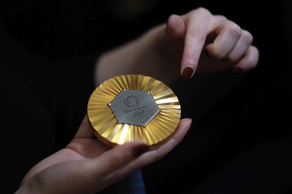 The Paris 2024 Olympic gold medal is presented to the press, in Paris, Thursday, Feb. 1, 2024. A hexagonal, polished piece of iron taken from the Eiffel Tower is being embedded in each gold, silver and bronze medal that will be hung around athletes' necks at the July 26-Aug. 11 Paris Games and Paralympics that follow. (AP Photo/Thibault Camus)