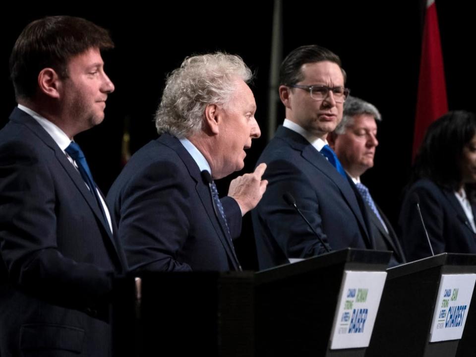 Conservative leadership candidates Jean Charest and Pierre Poilievre spar as Roman Baber, Scott Aitchison and Leslyn Lewis look on during a debate at the Canada Strong and Free Network conference, in Ottawa, Thursday, May 5, 2022. All of the candidates except Poilievre have expressed support for another debate. (Adrian Wyld/Canadian Press - image credit)