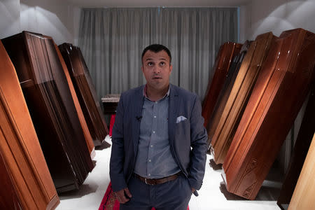 FILE PHOTO: Undertaker and candidate for town councillor at the municipality of Sykies, Konstantinos Baboulas, stands among coffins at his family's funeral parlor in Thessaloniki, Greece, May 17, 2019. REUTERS/Alkis Konstantinidis