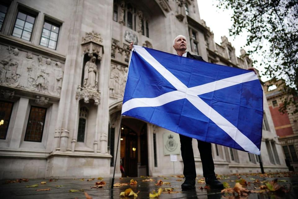 A Scottish independence supporter stands outside the Supreme Court in London <i>(Image: PA)</i>