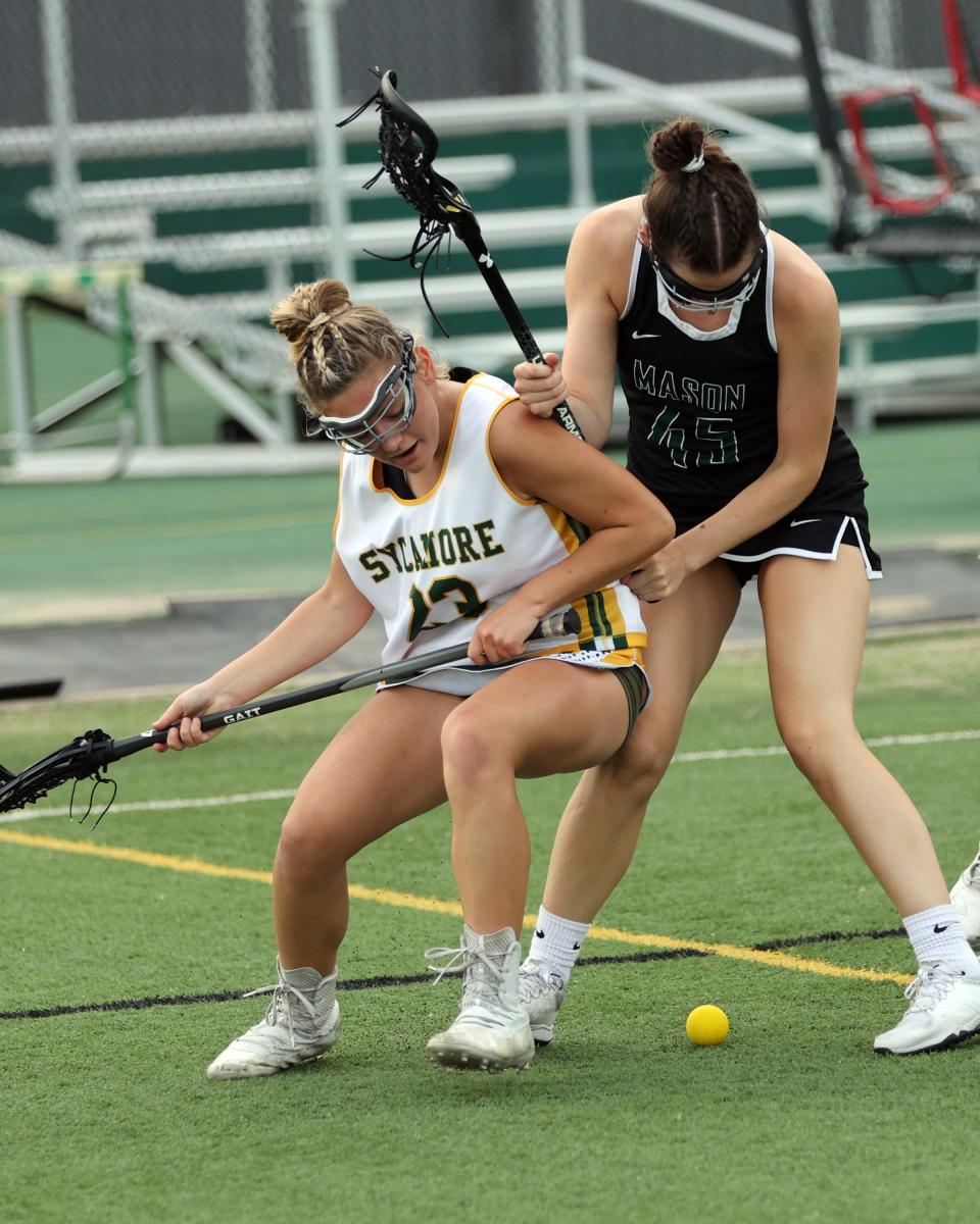 Sycamore attacker Lilly Nocito battles Mason defender Lexi Allen in the girls Division I lacrosse regional final game between Sycamore and Mason high schools May 25, 2022.