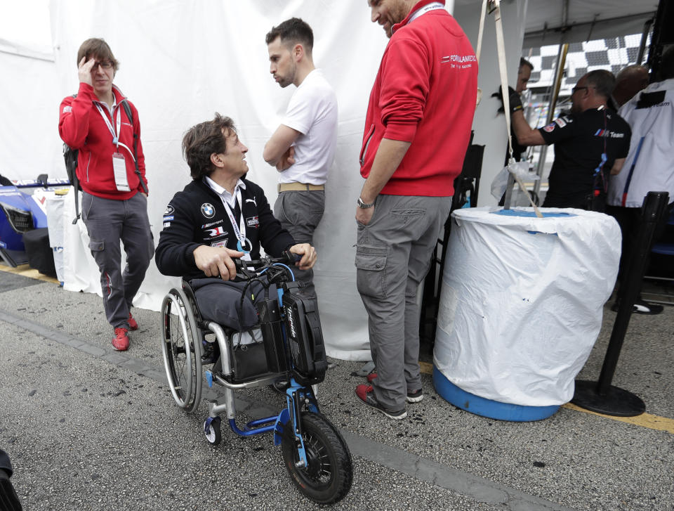 Alex Zanardi talks with visitors outside his pit stall during a practice session for the IMSA 24 hour race at Daytona International Speedway, Thursday, Jan. 24, 2019, in Daytona Beach, Fla. (AP Photo/John Raoux)