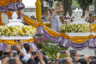 King Maha Vajiralongkorn, center, waves as he arrives to participate in a graduation ceremony at Thammasat University in Bangkok, Thailand, Friday, Oct. 30, 2020. (AP Photo/Sakchai Lalit)