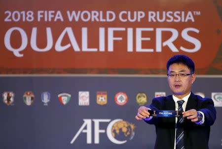 Asian Football Confederation's Shin Man Gil draws Palestine for Group A in the 2018 FIFA World Cup Asian qualifiers during the preliminary joint qualification round 2 draw in Kuala Lumpur, April 14, 2015. REUTERS/Olivia Harris