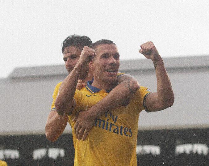 Arsenal's Lukas Podolski celebrates his second goal during the Barclays Premier League match at Craven Cottage, London.