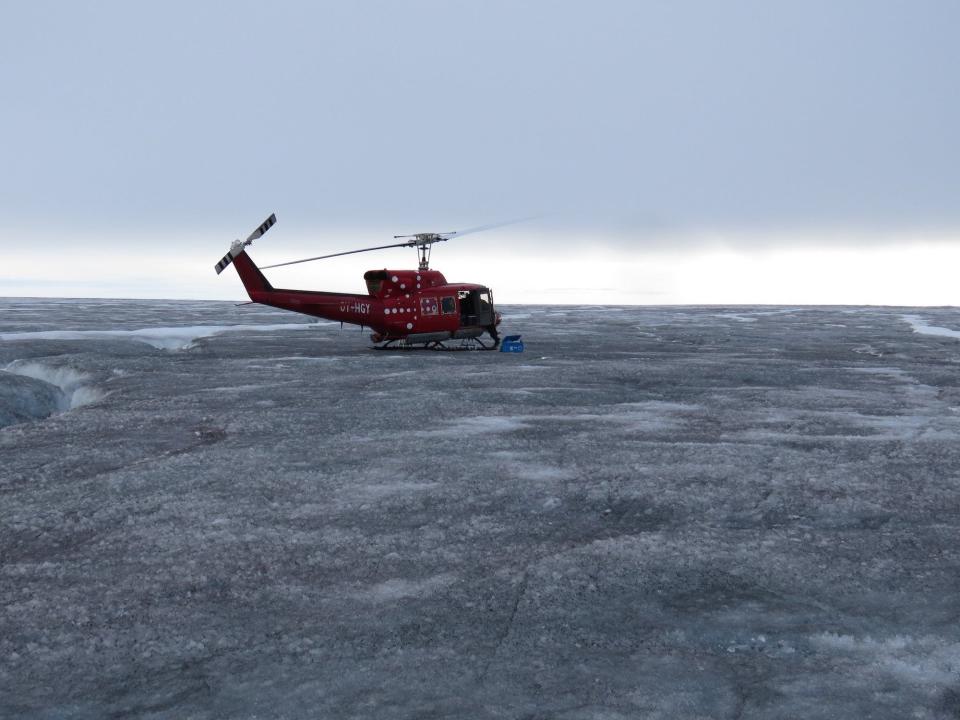 helicopter flies over black snow