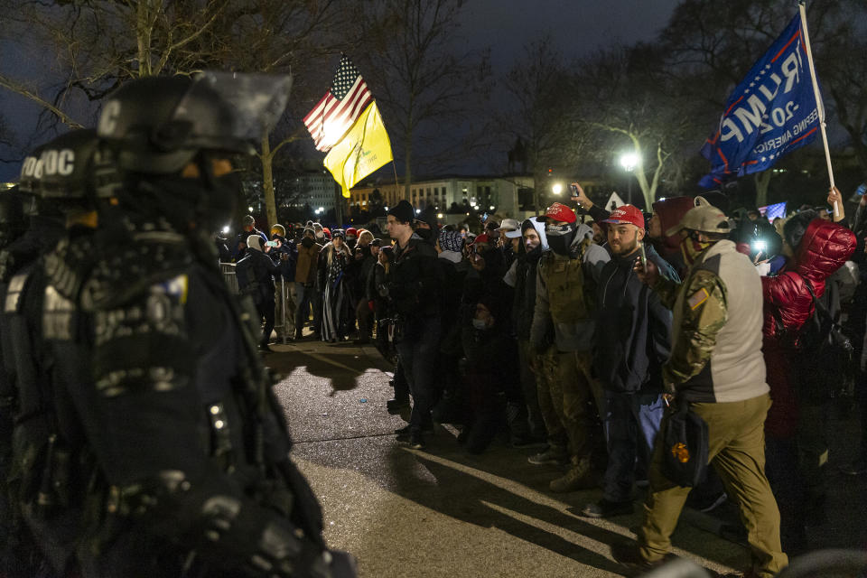 Police confront rioters around Capitol building where pro-Trump supporters rioted and breached the Capitol.  