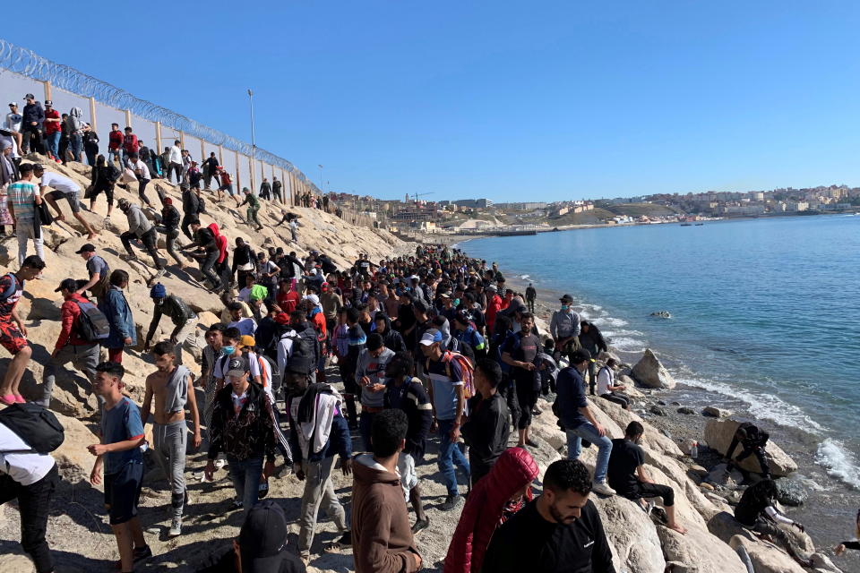 Dozens of people try to cross the border fence separating Fnideq in Morocco and the Spanish city of Ceuta, located in northern Africa. Source: EPA/Mohamed Siali