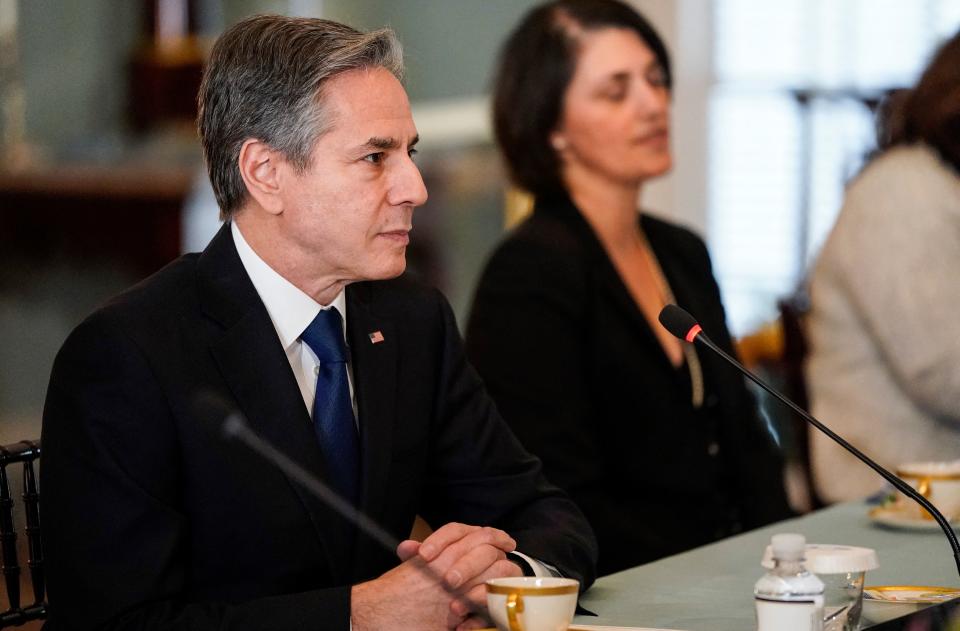 Secretary of State Antony Blinken seated at a microphone.