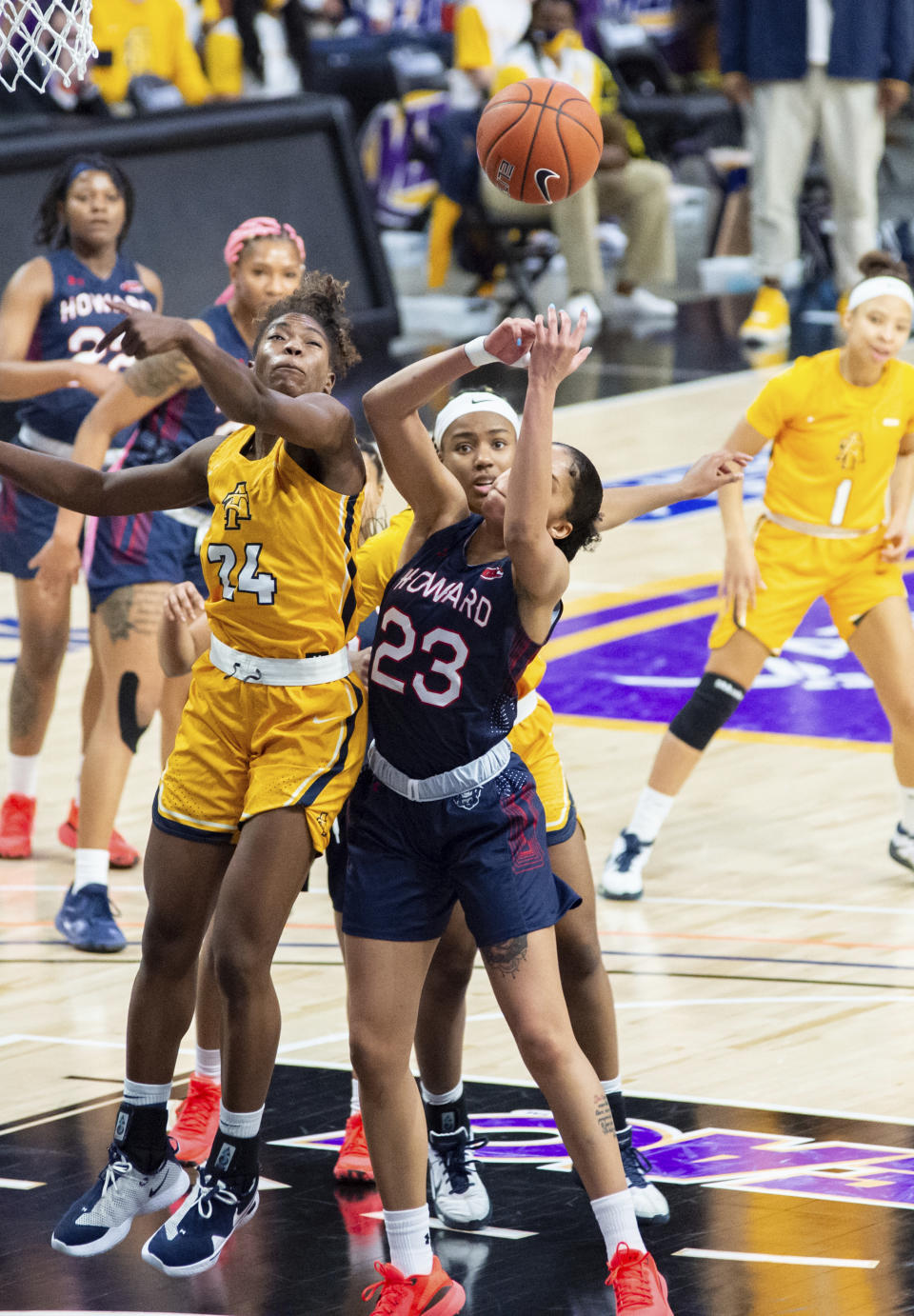 North Carolina A&T's Chanin Scott (24) knocks the ball loose from Howard's Jayla Thornton (23) during the first half of an NCAA college basketball game in the Mid-Eastern Athletic Conference championship Saturday, March 13, 2021, in Norfolk, Va. (AP Photo/Mike Caudill)