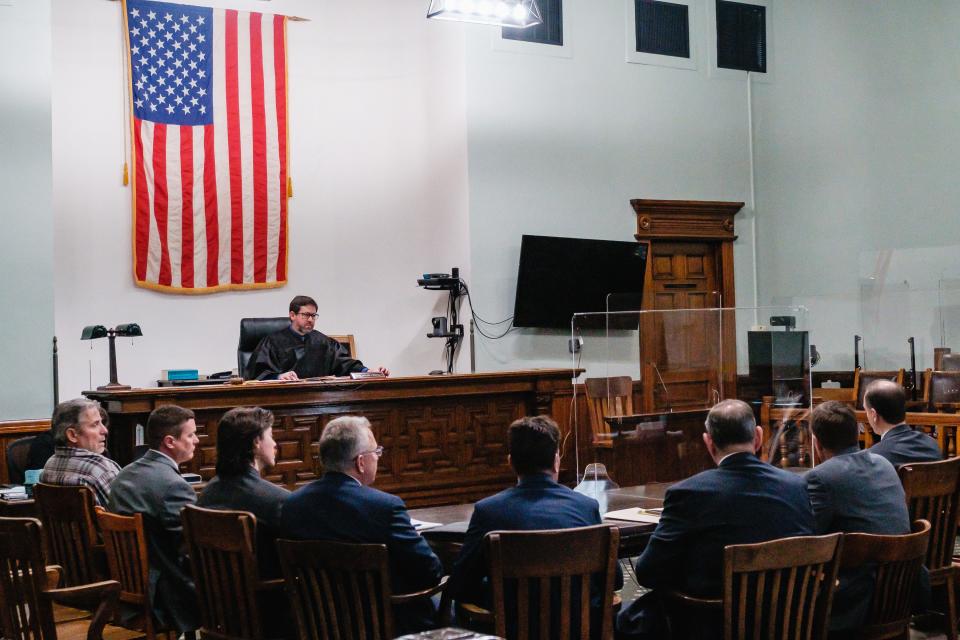 Carroll County Common Pleas Judge Michael V. Repella II handles court papers Thursday during the arraignment of former Carrollton Superintendent David Quattrochi, board member Michael Pozderac, teacher Mary "Jackie" Pozderac and Canton business owner Gus Nickolas for a series of theft-related charges involving Carrollton Exempted Village Schools.