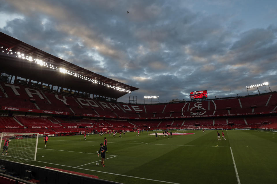 Sevilla and Betis players warm up before the start of their Spanish La Liga soccer match in Seville, Spain, Thursday, June 11, 2020. With virtual crowds, daily matches and lots of testing for the coronavirus, soccer is coming back to Spain. The Spanish league resumes this week more than three months after it was suspended because of the pandemic, becoming the second top league to restart in Europe. The Bundesliga was first. The Premier League and the Italian league should be next in the coming weeks. (AP Photo)