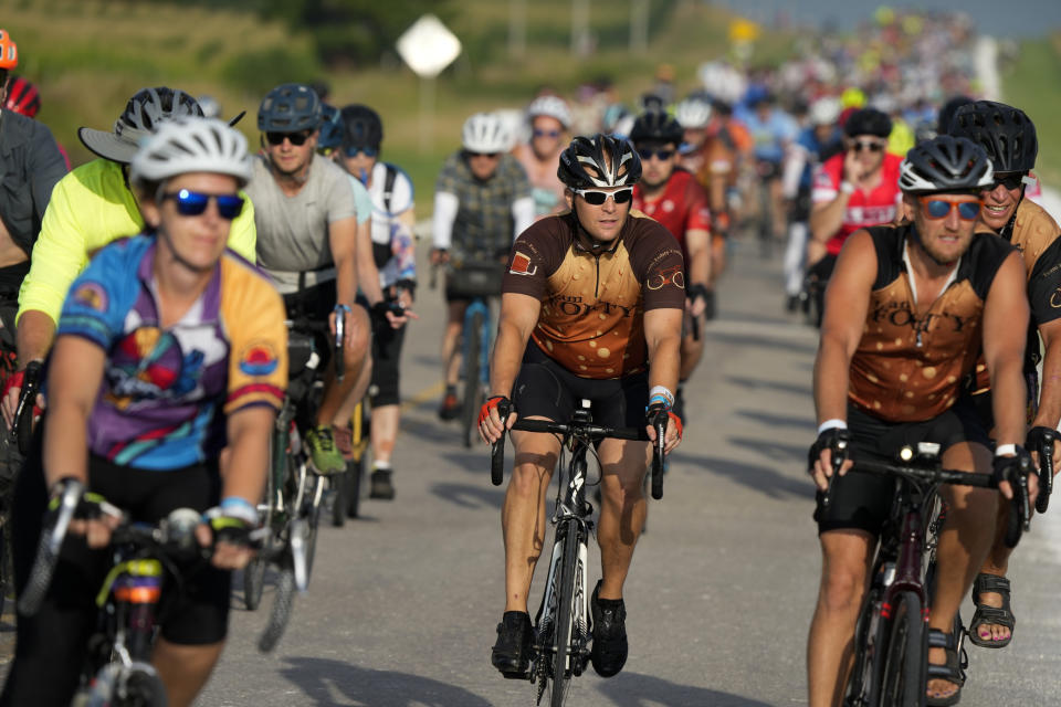 Associated Press reporter Dave Skretta, center, rides on a county road while riding in The Des Moines Register's annual bike ride across Iowa, also known as RAGBRAI, Tuesday, July 25, 2023, in Scranton, Iowa. (AP Photo/Charlie Neibergall)