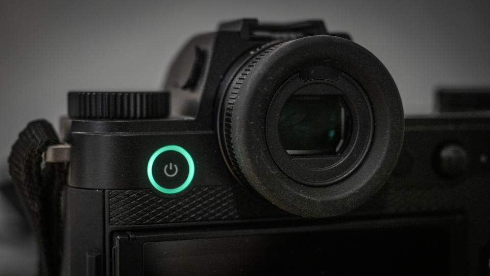 Leica SL3 camera on a wooden surface against a blue background