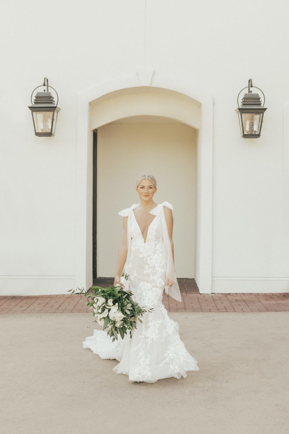 A bride stands in her wedding dress.