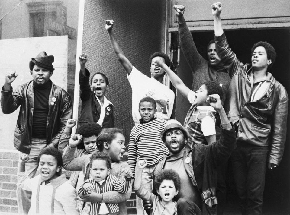 Black Panthers, teenagers, and children give the black panther salute outside their 'Liberation School' in the Fillmore district of San Francisco on Dec. 20, 1969.&nbsp;