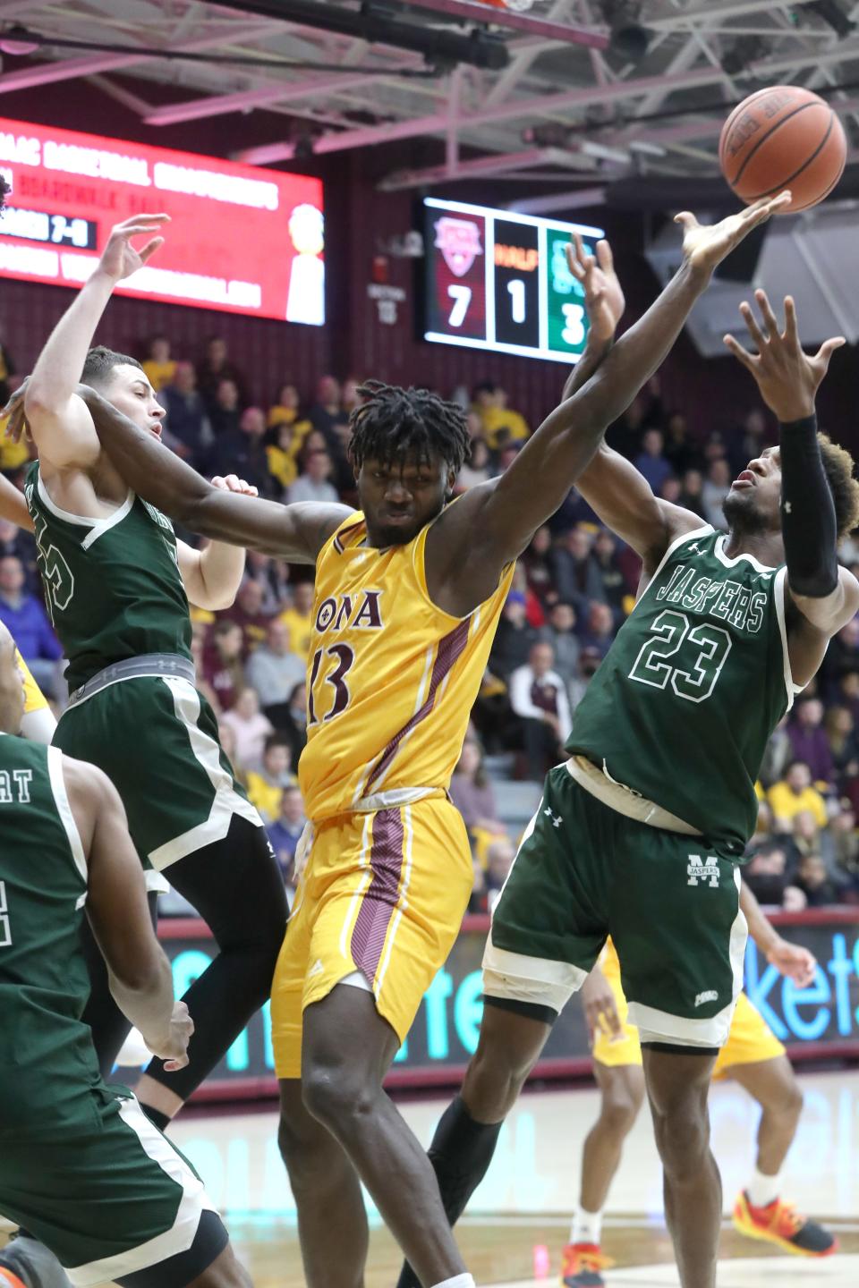 Iona's Nelly Junior Joseph reaches for a rebound with Manhattan's Josh Roberts during their game at Iona Feb. 17, 2023.