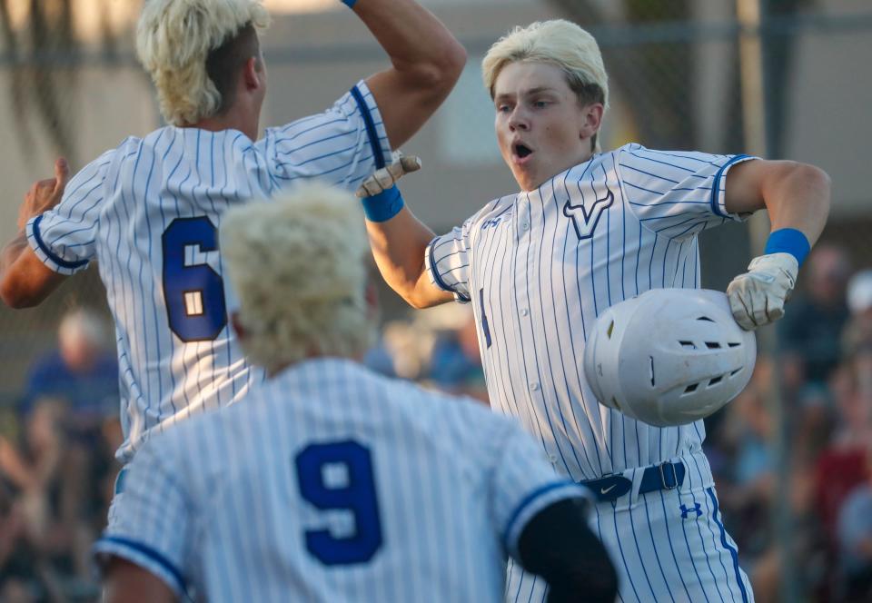 Lakeland Christian's Conor Browne (4) celebrates with Colby Brewington after hitting solo home run against Mount Dora Christian on Saturday night in the Class 2A, Region 2 semifinals at LCS.