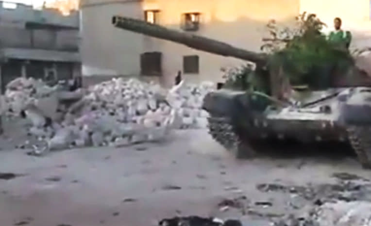 In this image made from amateur video released by the Ugarit News and accessed Tuesday, July 24, 2012, a Free Syrian Army solider drives a Syrian military tank in Aleppo, Syria. (AP Photo/Ugarit News via AP video) TV OUT, THE ASSOCIATED PRESS CANNOT INDEPENDENTLY VERIFY THE CONTENT, DATE, LOCATION OR AUTHENTICITY OF THIS MATERIAL