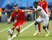 Switzerland's Granit Xhaka (L) is challenged by Juan Carlos Garcia of Honduras during their 2014 World Cup Group E soccer match at the Amazonia arena in Manaus June 25, 2014. REUTERS/Dominic Ebenbichler (BRAZIL - Tags: SOCCER SPORT WORLD CUP)