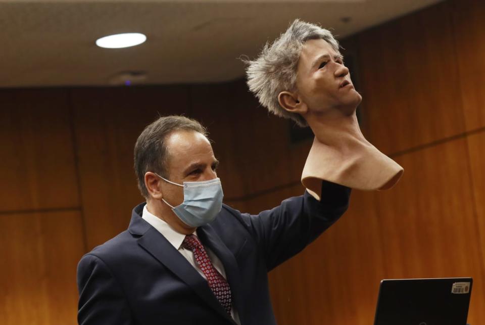 <div class="inline-image__caption"><p>Deputy District Attorney Habib A. Balian holds a rubber latex mask, donned by Robert Durst when police arrested him along with a fake ID and more than $42,000 in cash.</p></div> <div class="inline-image__credit">Pool/Getty</div>