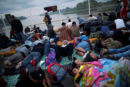 Migrantes hondureños, parte de una caravana que intenta llegar a Estados Unidos, esperan en el puente que conecta México y Guatemala en Ciudad Hidalgo, México, 20 de octubre de 2018. REUTERS/Ueslei Marcelino