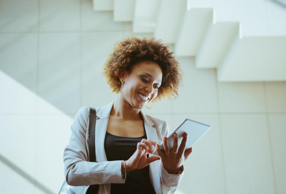 An investor smiles while looking at something on a phone.