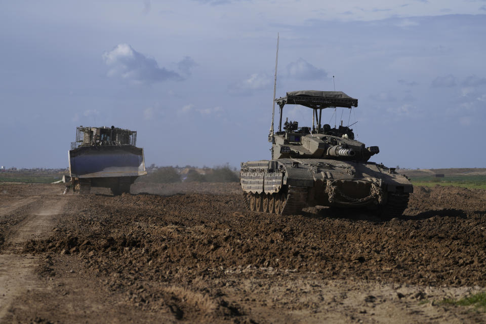 An Israeli tank and a military bulldozer return from the Gaza Strip, as they drive in southern Israel, near the Gaza border, Thursday, Feb. 1, 2024. (AP Photo/Tsafrir Abayov)