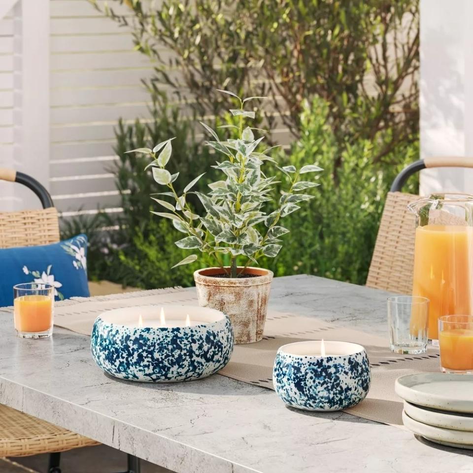 Outdoor table setting with plant, candles, and drinks, showcasing home decor products