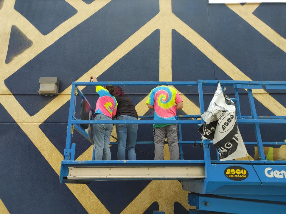 Local art group Blank Spaces puts its final touchups on its new mural for the Hoodoo Festival Oct. 2.