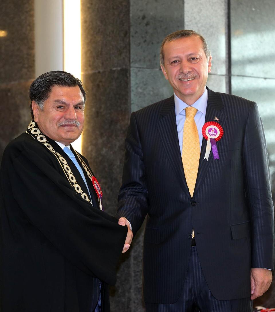 Constitutional Court Chief Justice Hasim Kilic, left, shakes hands with Prime Minister Recep Tayyip Erdogan in Ankara, Turkey, Friday, April 25, 2014. Turkey's most senior judge has delivered a sharp rebuke to Prime Minister Recep Tayyip Erdogan for criticizing his court's decisions, including one that lifted a ban on Twitter on the grounds that it violated freedoms. Erdogan reluctantly complied with the high court ruling to unblock Twitter earlier this month. Erdogan said, however, that he did not respect the ruling and described it as being against national interests. (AP Photo)