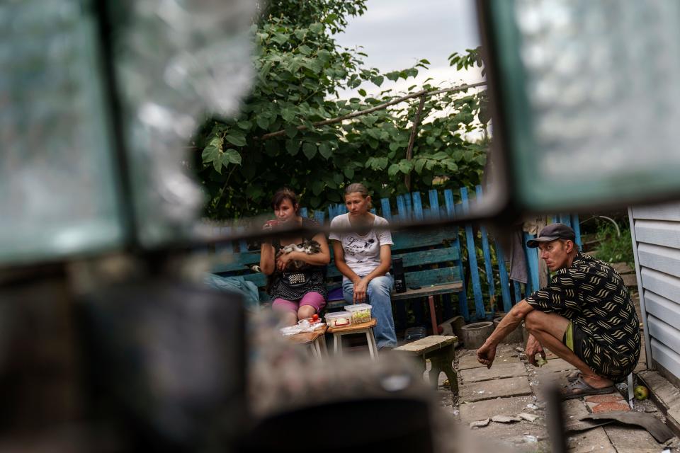 Friends gather Saturday, Aug. 13, 2022, at the damaged home of Ivan Fartukh, who was killed in a Russian rocket attack last night in Kramatorsk, Donetsk region, eastern Ukraine. According to the mayor, the strike killed three people and wounded 13 others. The attack came less than a day after 11 other rockets were fired at the city, one of the two main Ukrainian-held ones in Donetsk province, the focus of an ongoing Russian offensive to capture eastern Ukraine's Donbas region.