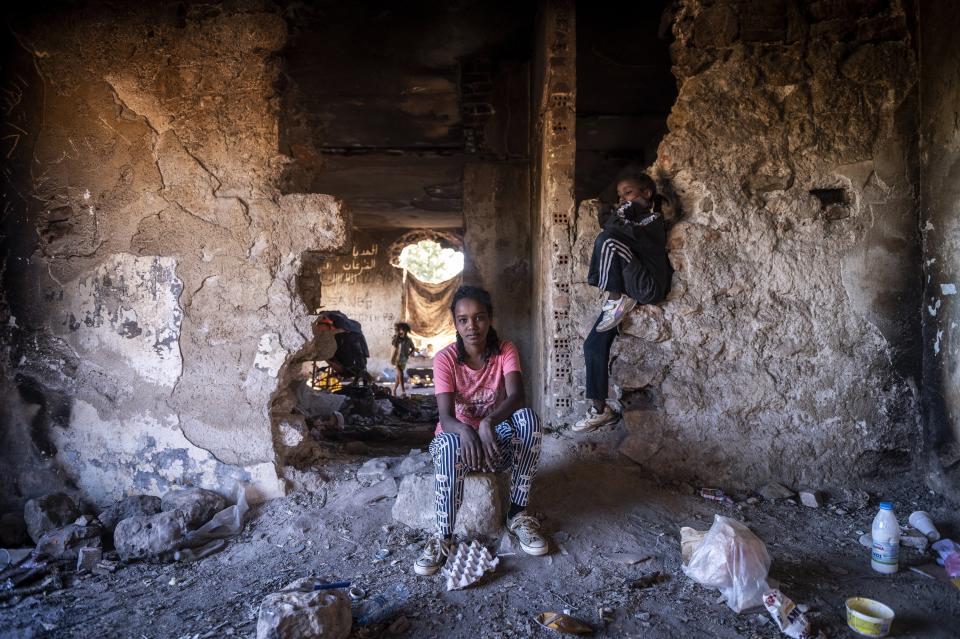 Sudanese girls sit inside an abandoned army outpost near Ieropigi village, northern Greece, at the Greek - Albanian border, on Saturday, Sept. 25, 2021. A relatively smooth section of Greece's rugged border with Albania is turning into a major thoroughfare north for migrants in Greece seeking a better life in Europe's prosperous heartland. (AP Photo/Giannis Papanikos)