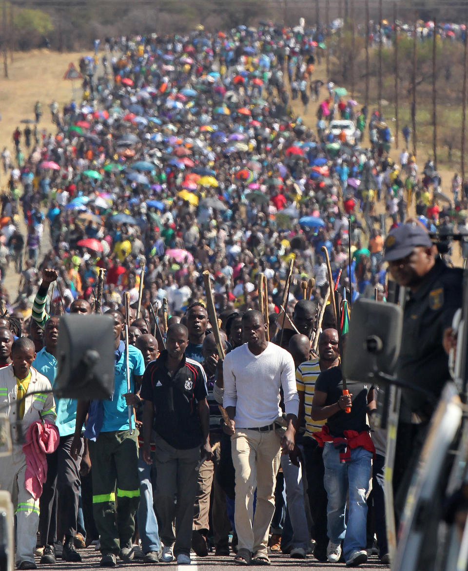 FILE In this photo taken Monday Sept. 10, 2012 miners march to Lonmin Platinum Mine near Rustenburg, South Africa in an attempt to stop operations. The current unrest in the mining industry started in August with the miners staging a wildcat strike that led to a violent confrontation in which police shot and killed 34. More than 70 others were wounded in the worst case of of state-led violence since the end of apartheid. (AP Photo/Themba Hadebe-file)