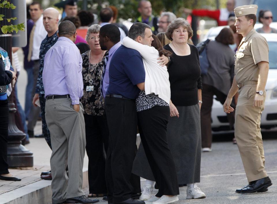 Navy Yard workers evacuated after the shooting are reunited with loved ones at a makeshift Red Cross shelter at the Nationals Park baseball stadium near the affected naval installation in Washington, September 16, 2013. (REUTERS/Jonathan Ernst)