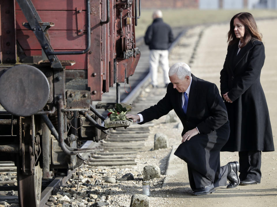 United States Vice President Mike Pence kneels beside his wife Karen, right, at a historic freight car during their visit to the former Nazi concentration camp Auschwitz-Birkenau in Oswiecim, Poland, Friday, Feb. 15, 2019. The freight car was used to transport Jews to the death camp. (AP Photo/Michael Sohn)