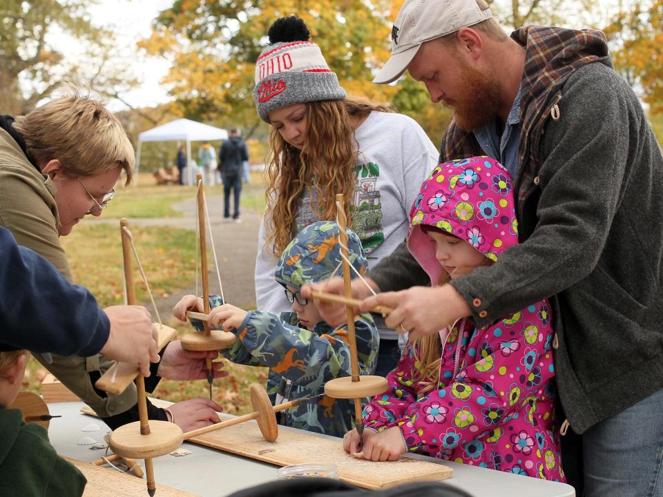 Andrew Heminger and Jenna Howard, of Newark, help Ardore, 6, and Andrew, 5, operate pump drills to make holes in shells. The Ohio History Connection held events on Sunday, October 15, 2023, at the Great Circle and Octagon Earthworks to celebrate their designation as UNESCO World Heritage Sites.