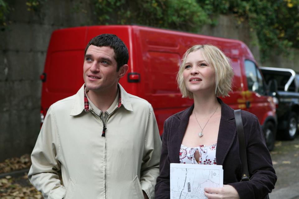 a man and woman standing next to each other and looking at the camera