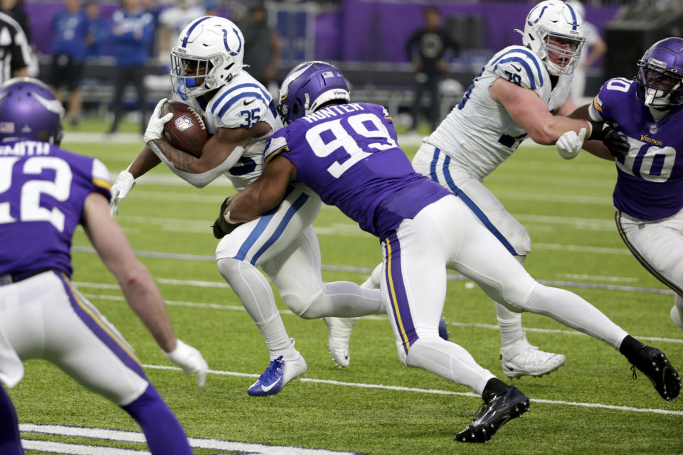 Indianapolis Colts running back Deon Jackson (35) tries to break a tackle by Minnesota Vikings linebacker Danielle Hunter (99) during the first half of an NFL football game, Saturday, Dec. 17, 2022, in Minneapolis. (AP Photo/Andy Clayton-King)