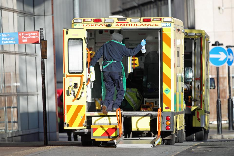 A worker in PPE cleans the back of an ambulance after dropping off a patient at the Royal London Hospital during the second wave of coronavirus in January (Yui Mok/PA) (PA Archive)