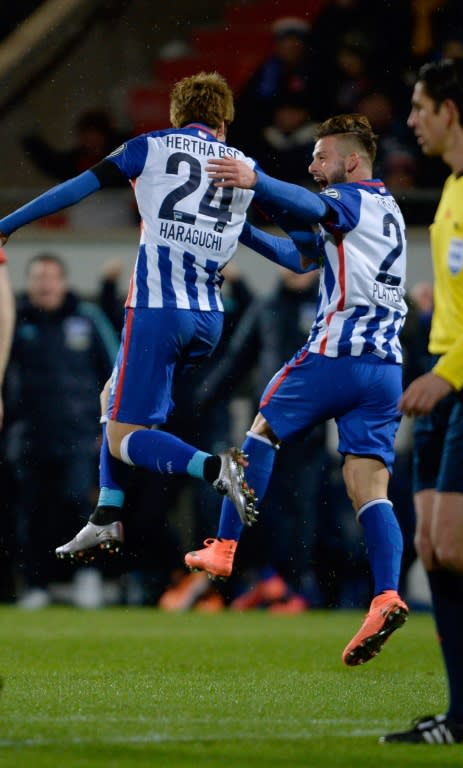 Hertha's midfielder Genki Haraguchi (L) celebrates scoring with his team-mate defender Marvin Plattenhardt during the German Cup quarter final football match Heidenheim vs Hertha Berlin on February 10, 2016 in Heidenheim, Germany