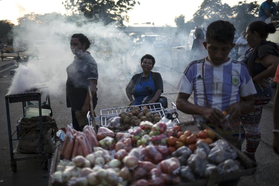 In this Nov. 15, 2019 photo, street vendors wait for customers in "Las Pulgas" market in Maracaibo, Venezuela. In Maracaibo, located in Venezuela’s western Zulia state along the Colombian border, many residents say they’ve abandoned political marches, lacking faith in leaders or fearing for their personal safety. (AP Photo/Rodrigo Abd)