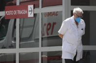 A doctor gets some fresh air as he takes a walk outside the HRAN Hospital in Brasilia, Brazil, Wednesday, March 3, 2021. The number of new COVID-19 cases in Brazil is still surging, with a new record high of deaths reported on Tuesday. (AP Photo/Eraldo Peres)
