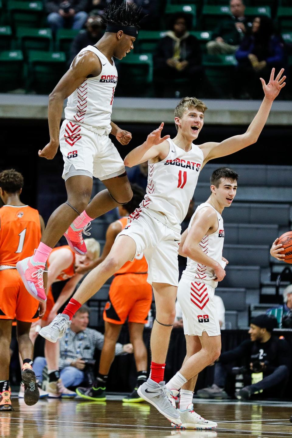 Grand Blanc's Bryce O'Mara (11) celebrates a basket against Belleville with teammate Tae Boyd during the first half of an MHSAA Division 1 boys basketball state semifinal at Breslin Center in East Lansing on Friday, March 25, 2022.