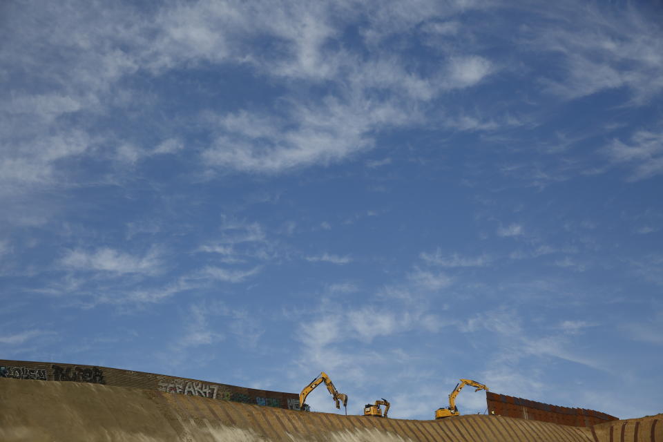 FILE- Workers replace sections of the border wall separating San Diego from Tijuana, Mexico, left, with new sections, right, Tuesday, Jan. 8, 2019, seen from Tijuana. Top Trump administration officials will visit South Texas five days before Election Day to announce they have completed 400 miles of U.S.-Mexico border wall, attempting to show progress on perhaps the president's best-known campaign promise four years ago. But most of the wall went up in areas that already had smaller barriers. (AP Photo/Gregory Bull)