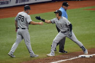 New York Yankees' Gio Urshela, right, celebrates with third base coach Phil Nevin after his two-run single off Tampa Bay Rays relief pitcher Collin McHugh during the 10th inning of a baseball game Sunday, April 11, 2021, in St. Petersburg, Fla. (AP Photo/Chris O'Meara)