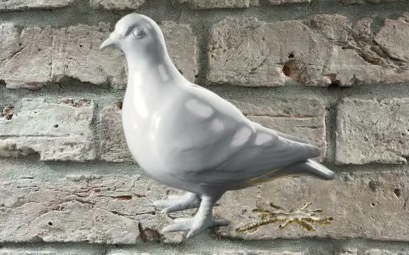 London Museum's new logo: a white clay pigeon under which lies a golden piece of bird poo