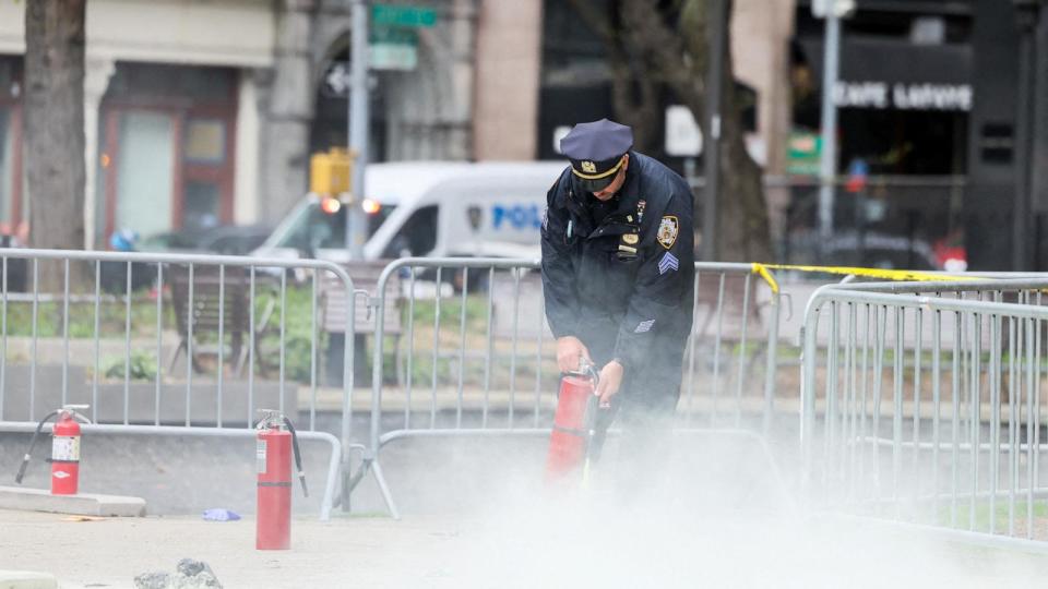 PHOTO: A police officer uses a fire extinguisher as emergency personnel respond to a report of a person covered in flames, outside the courthouse where former President Donald Trump's  trial in New York, April 19, 2024.  (Brendan Mcdermid/Reuters)